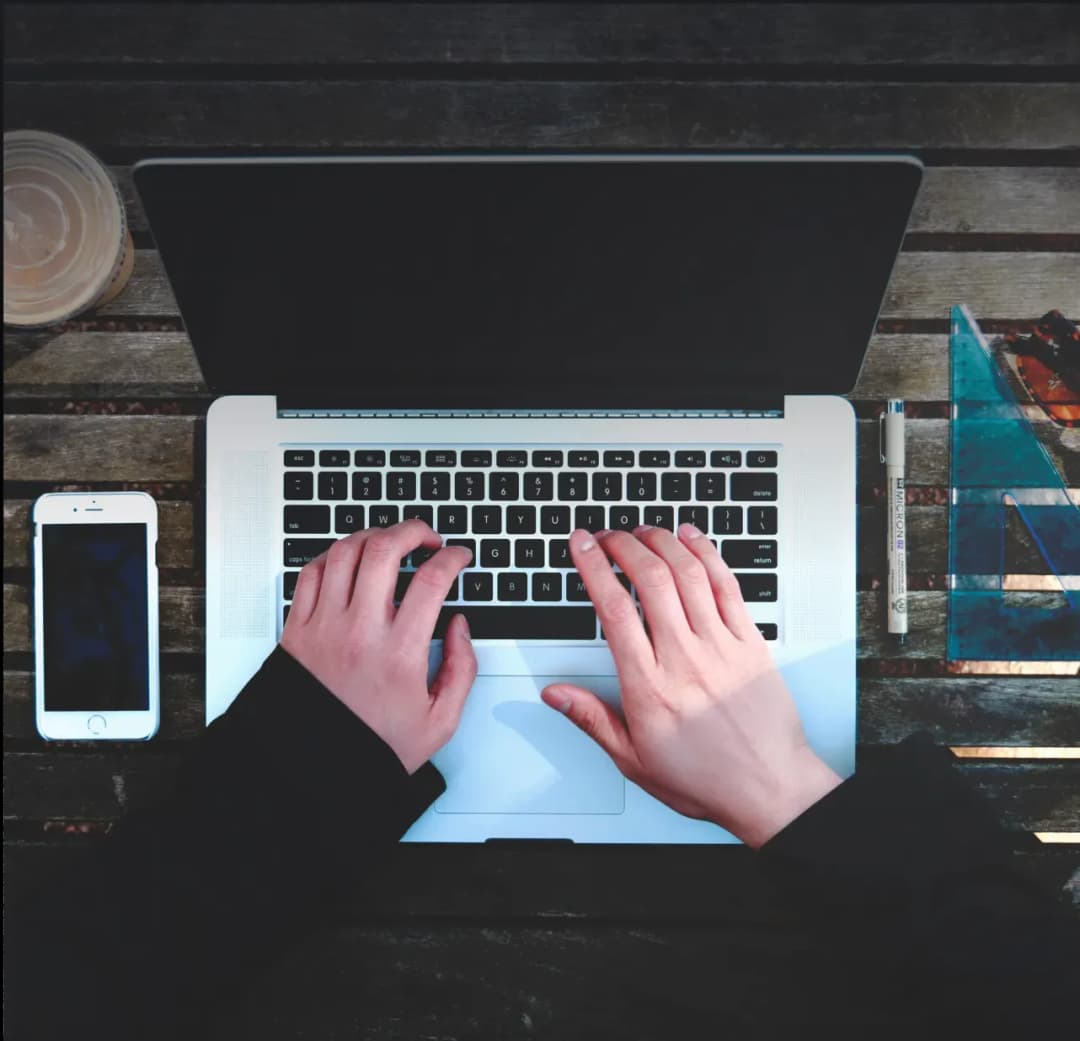 Hands typing on a laptop keyboard