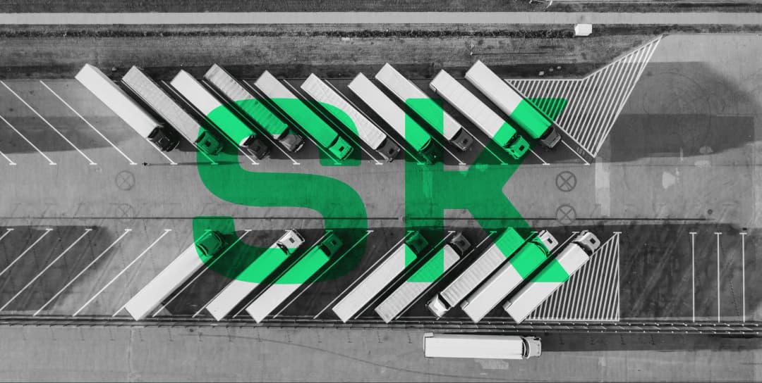 Trucks arranged in parking lot with green letters SK