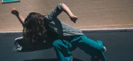 Person dancing outdoors in casual clothing