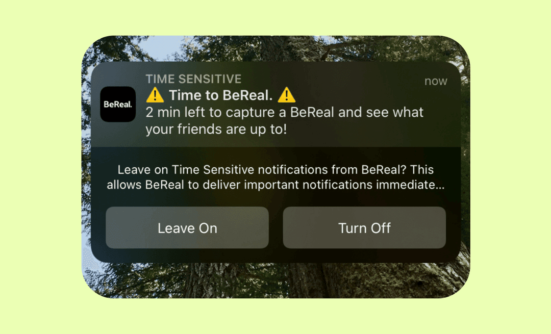 iOS Time Sensitive push from BeReal with Leave On and Turn Off options over a forest photo