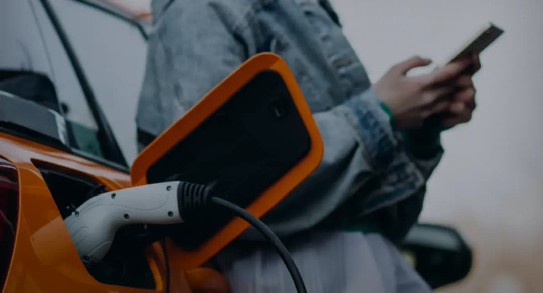 Electric vehicle charging with person using phone