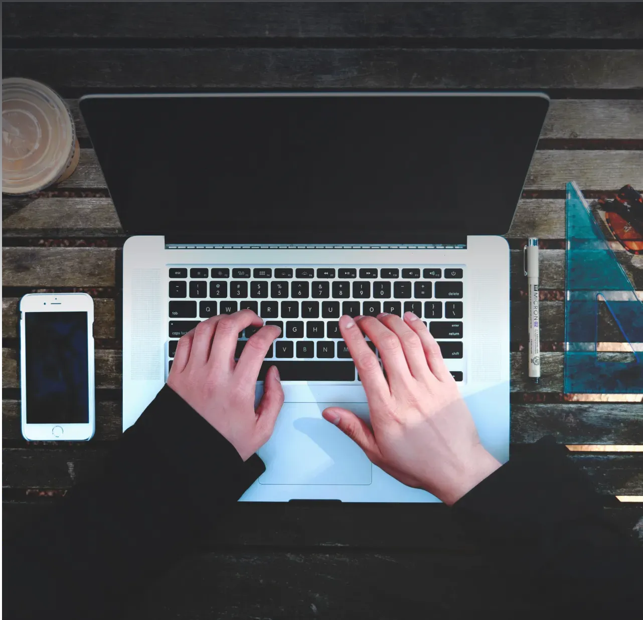 Hands typing on a laptop keyboard