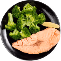 Salmon with broccoli and ginger on black plate