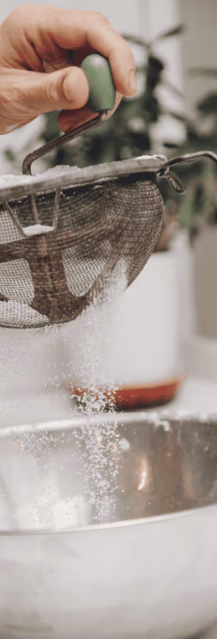 Sifting sugar through a mesh strainer