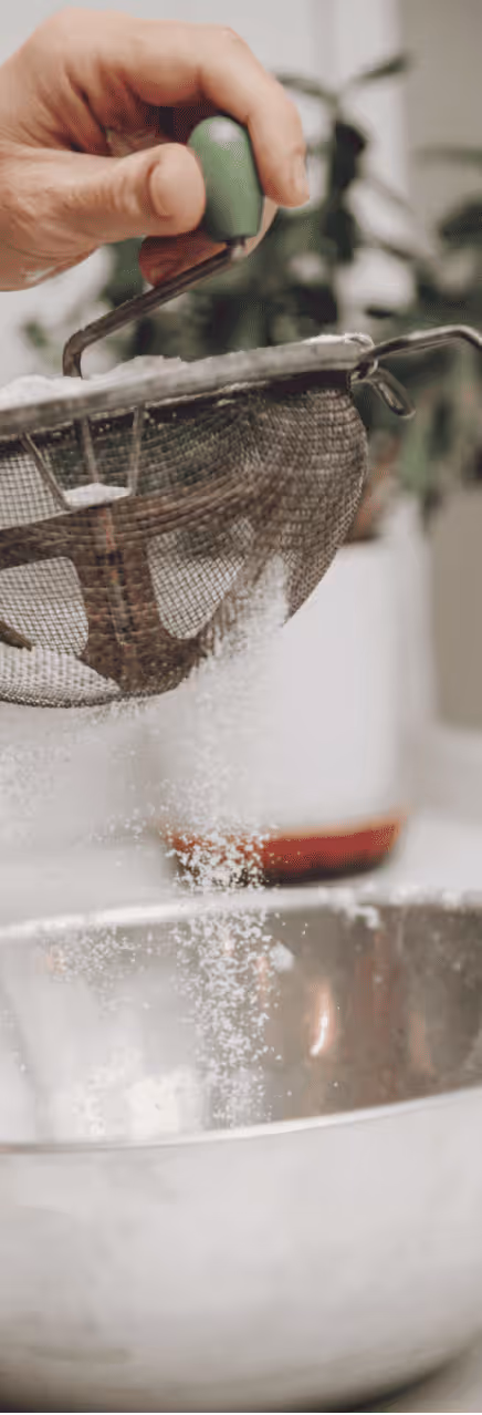 Sifting flour into a mixing bowl