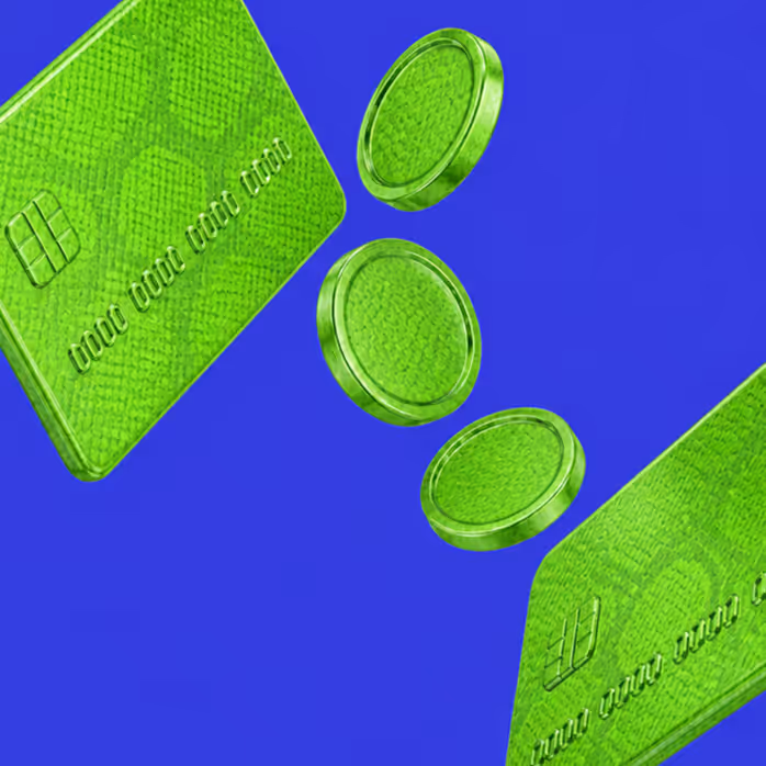 Two green credit cards and three green coins on a blue background.